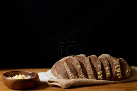 Photo for Closeup of decorated brown bread on wooden table. Dark composition. Bakery concept. - Royalty Free Image
