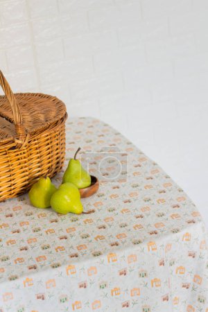 Foto de Cesta de picnic con peras jugosas en la mesa - Imagen libre de derechos
