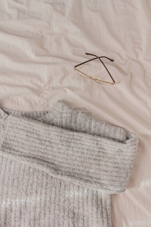 Foto de Composición invernal, gafas y suéter gris. Estilo de vida, concepto estacional del espacio de trabajo. - Imagen libre de derechos