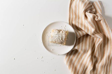 Téléchargez les photos : Délicieux gâteau à la noix de coco avec tissu beige sur fond blanc - en image libre de droit
