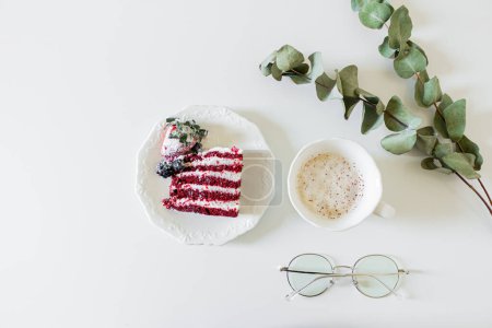 Téléchargez les photos : Composition petit déjeuner avec gâteau de velours rouge et une tasse de lait et de café sur fond blanc. Couché plat, vue du dessus. - en image libre de droit
