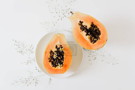 Photo for Summer concept. Minimalist fresh food composition. Top view of tropical orange papaya fruit halves on white background. - Royalty Free Image
