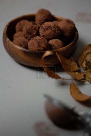 Foto de Cuenco de madera de trufas de chocolate cubiertas con cacao en polvo. Delicioso concepto de postre. - Imagen libre de derechos