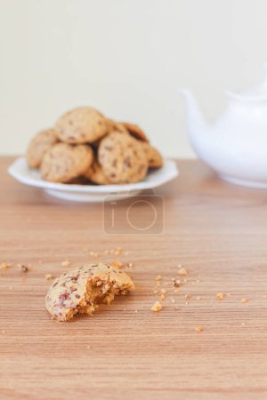 Téléchargez les photos : Délicieux biscuits dans une assiette en céramique avec théière blanche sur une table en bois - en image libre de droit