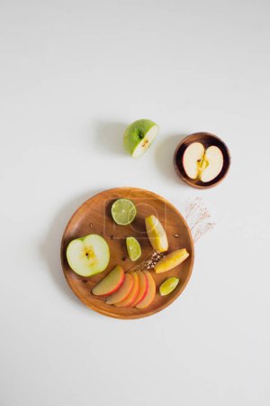 Foto de Vista superior de manzanas en rodajas y limón sobre platos de madera - Imagen libre de derechos