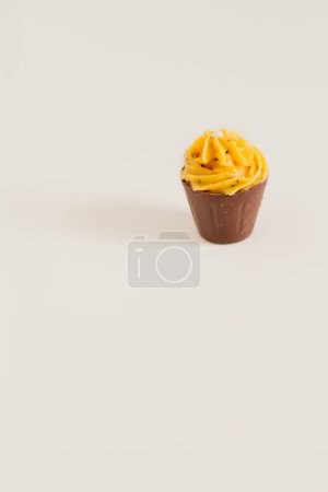 Téléchargez les photos : Vue rapprochée du cupcake avec glaçage jaune sur fond clair - en image libre de droit