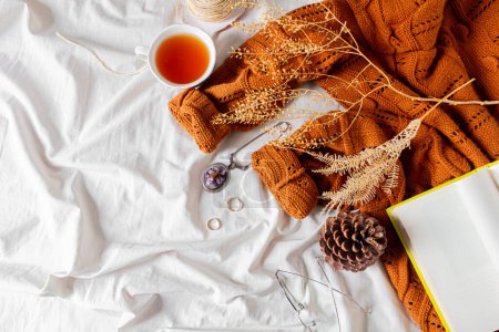Photo for Women fashion composition. Warm female woolen knitted sweater, tea on white bed sheet background. Autumn composition. - Royalty Free Image