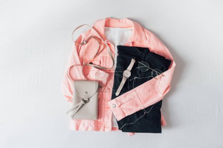 Foto de Hermosa chaqueta de color rosa pálido de moda y accesorios sobre fondo de sábana blanca. Concepto de moda. Piso tendido, vista superior. - Imagen libre de derechos