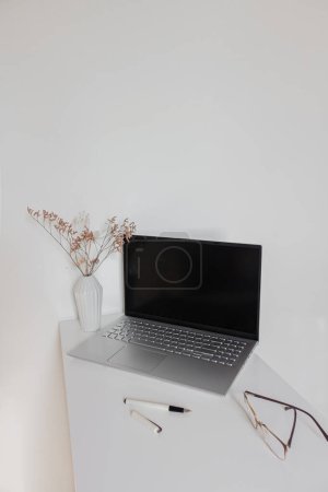 Téléchargez les photos : Bureau à domicile espace de travail avec ordinateur portable et lunettes sur bureau blanc. Concept d'entreprise - en image libre de droit