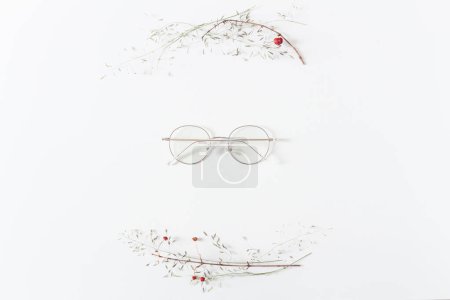 Photo for Creative arrangement frame made of dried plants with isolated eyeglasses in the middle - Royalty Free Image