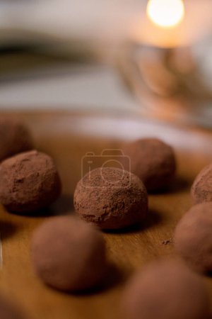 Photo for Delicious dessert concept.  Closeup view of chocolate truffles covered with cocoa powder on wooden plate. - Royalty Free Image