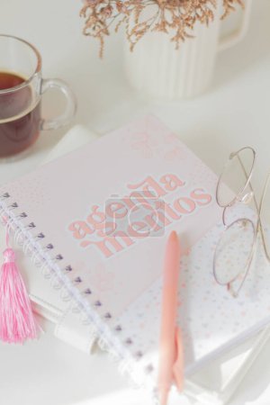 Téléchargez les photos : Composition féminine avec cahier, stylo, verres et tasse de thé sur fond blanc. - en image libre de droit