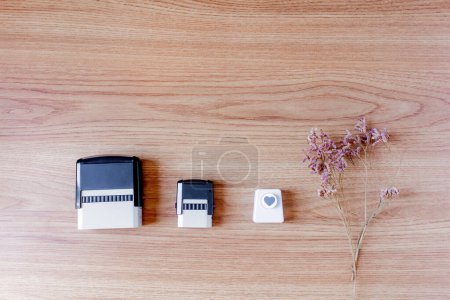 Photo for Stamps and heart paper cutter with lilac flowers on wooden background. - Royalty Free Image