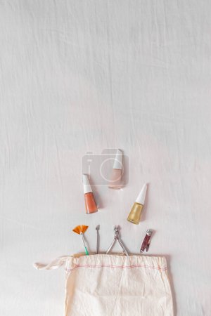 Téléchargez les photos : Blog beauté, composition manucure avec vernis à ongles et outils manucure provenant d'un sac en coton - en image libre de droit
