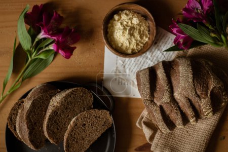 Foto de Rebanadas de pan marrón en la mesa de madera. Composición oscura. Concepto de panadería. - Imagen libre de derechos