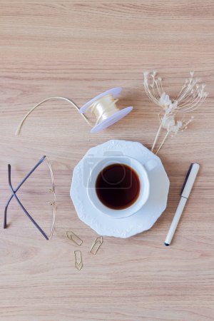Téléchargez les photos : Tasse de café, stylo, trombones, verres, ficelle et fleurs séchées sur fond en bois. - en image libre de droit