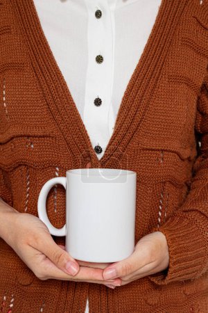 Photo for Young pretty woman in brown sweater and white shirt holding white mug. Fall, autumn fashion composition. - Royalty Free Image