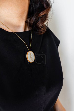 Photo for Young pretty woman in black blouse and skirt, and classic necklace against the white wall. Minimal fashion composition. - Royalty Free Image
