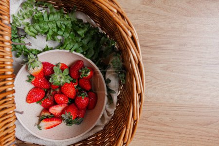 Photo for Strawberries inside a picnic basket with fern leaves - Royalty Free Image