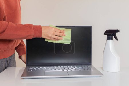 Téléchargez les photos : Plan recadré de jeune femme nettoyant un ordinateur portable - en image libre de droit