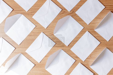 Téléchargez les photos : Groupe d'enveloppes blanches à plat posé sur une table en bois - en image libre de droit