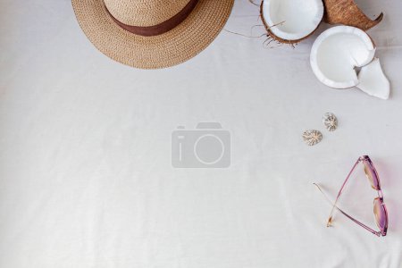 Téléchargez les photos : Chapeau de paille, noix de coco et lunettes de soleil. Accessoire féminin pour l'été. Concept de mode. - en image libre de droit
