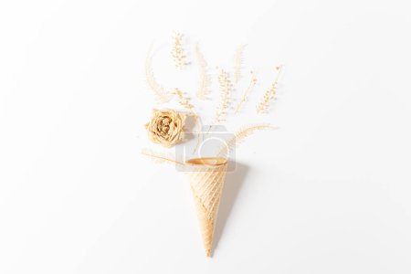 Photo for Waffle cone with dried flowers and leaves on white background. Flat lay, top view, floral background. Spring, summer concept. - Royalty Free Image