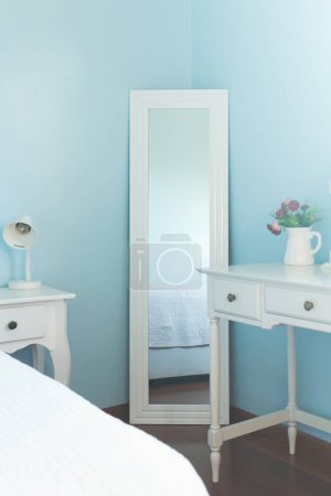 Photo for Bed reflection in the mirror. Modern feminine classic design in blue colors. Comfortable home interior. - Royalty Free Image