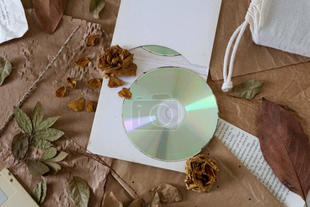 Foto de Vista superior del viejo disco compacto con flores secas sobre papel vintage - Imagen libre de derechos