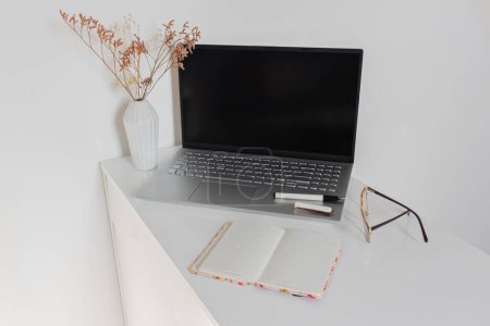 Photo for Home office desk workspace on white desk with laptop, notebook and eyeglasses - Royalty Free Image