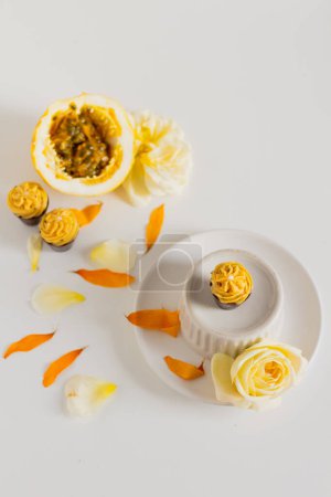 Foto de Cupcakes caseros con fruta de la pasión y pétalos florales alrededor - Imagen libre de derechos