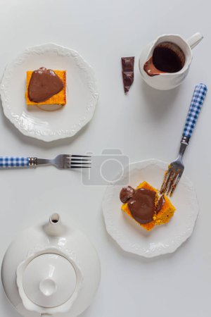 Téléchargez les photos : Table de service avec tranches de gâteau à la carotte brésilienne, cruche au chocolat et théière - en image libre de droit