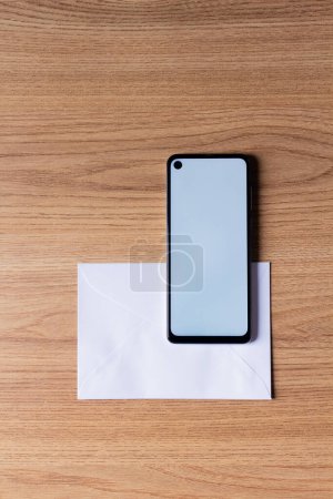 Téléchargez les photos : Téléphone portable et enveloppe sur une table en bois - en image libre de droit