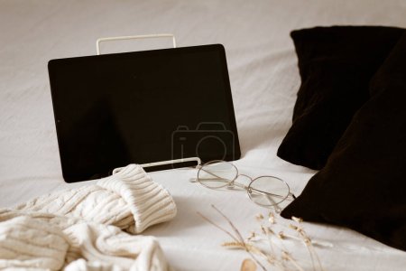 Photo for A Digital tablet on the bed with black pillows - Royalty Free Image