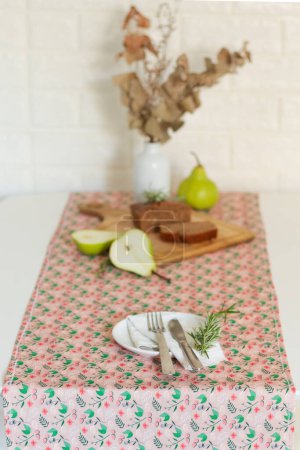Foto de Composición del desayuno. pastel de nuez en la tabla de cortar con peras verdes y eucalipto seco en el fondo - Imagen libre de derechos
