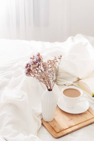 Photo for Breakfast on dark wooden vintage tray in bed with light beige sheet and pillows. Flat lay, top view. Slow romantic morning concept. - Royalty Free Image