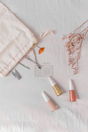 Foto de Composición con esmalte de uñas, bolsa de algodón y herramientas de manicura. Blog de belleza, concepto de manicura. - Imagen libre de derechos