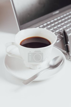 Téléchargez les photos : Tasse de café près de l'ordinateur portable et stylo sur le clavier - en image libre de droit