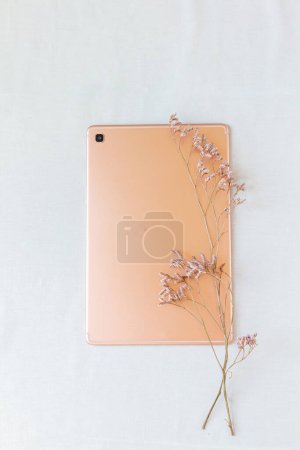 Téléchargez les photos : Vue du dessus de la tablette numérique décorée de fleurs lilas sur blanc - en image libre de droit