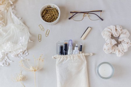 Foto de Moderno escritorio de oficina en casa minimalista con cuaderno, gafas, bolígrafo, ramo de flores silvestres y artículos estacionarios sobre fondo blanco - Imagen libre de derechos