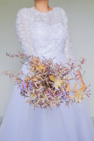 Photo for Young and pretty bride holding a dried flower bouquet - Royalty Free Image