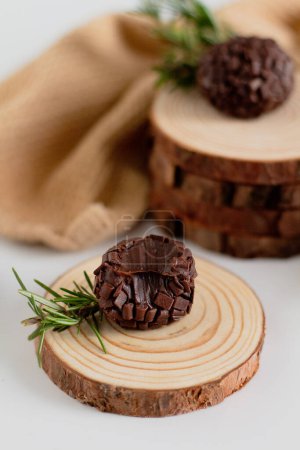 Foto de Caramelos tradicionales brasileños brigadeiro decorados con maderas de pino. Composición estética. Estilo de alimentos. - Imagen libre de derechos