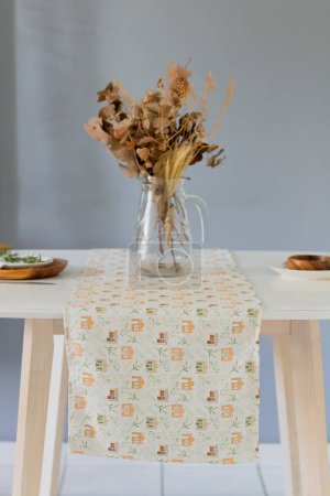 Téléchargez les photos : Vue rapprochée du bouquet séché en vase sur nappe colorée - en image libre de droit