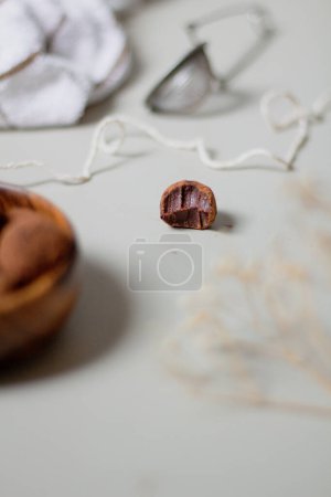 Photo for Chocolate truffles covered with cocoa powder in wooden bowl and one candy on table. Gray background. Delicious dessert concept. - Royalty Free Image