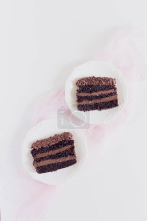 Photo for Two plates with chocolate cake pieces decorated with pink cloth. Party comfort food concept. - Royalty Free Image