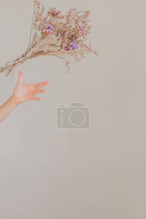 Téléchargez les photos : Main féminine essayant d'attraper bouquet de fleurs séchées - en image libre de droit