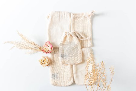 Foto de Composición con bolsas de algodón y flores y hojas secas. - Imagen libre de derechos