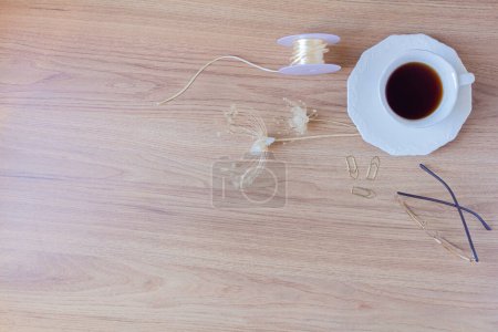 Foto de Taza de café, bolígrafo, clips, vasos, cuerdas y flores secas y hojas sobre un fondo de madera. Piso tendido, vista superior. - Imagen libre de derechos