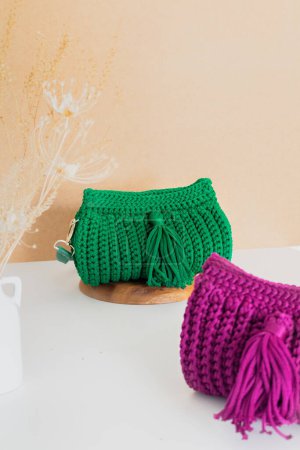 Téléchargez les photos : Vert et violet femelle sacs crochet tendance sur fond beige. Concept de mode - en image libre de droit