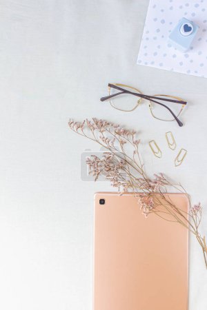 Photo for Flat lay of rose gold tablet with cozy space mock up. Top view home office desk workspace decorated with dried flower branches and stationery supplies. - Royalty Free Image